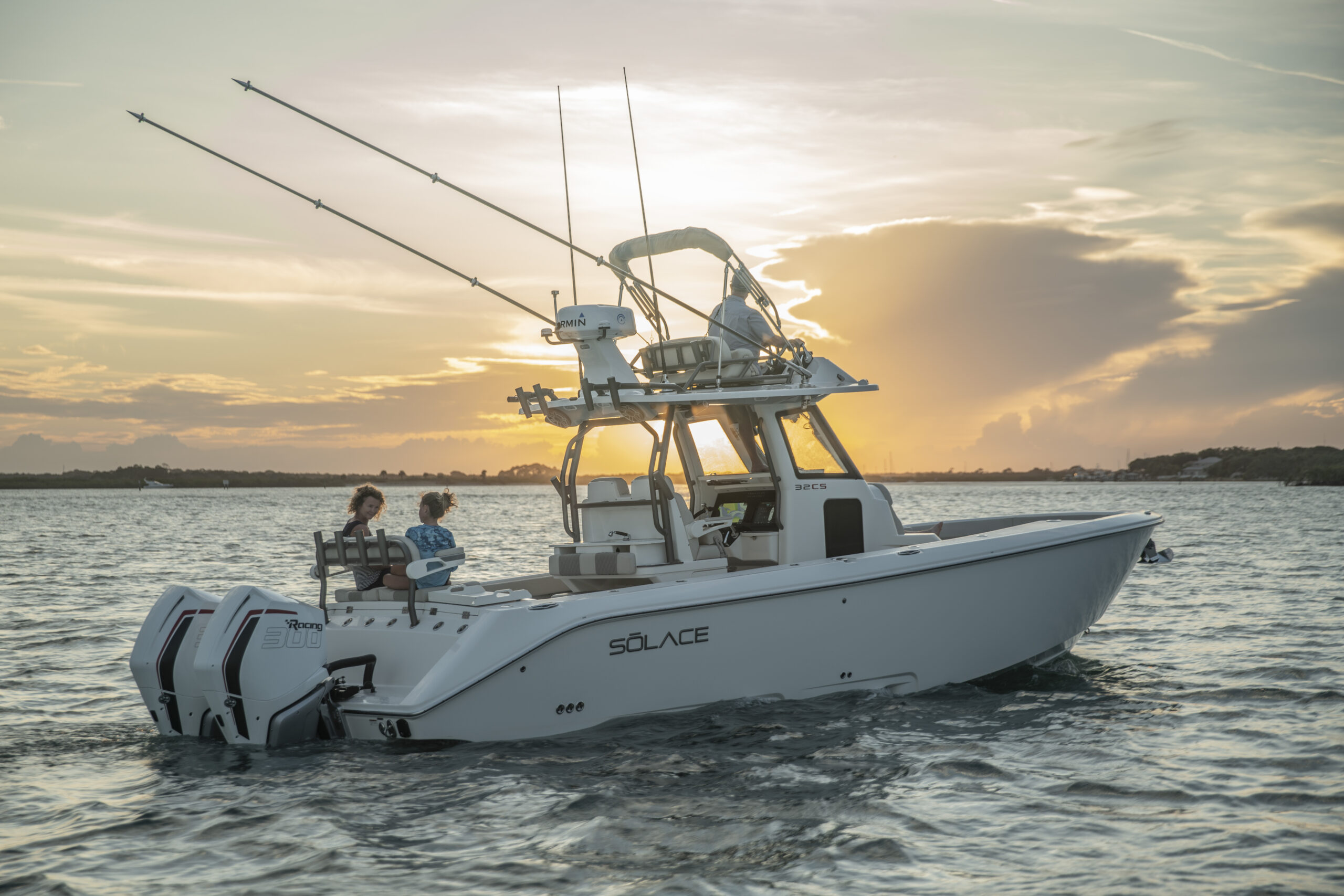 Justin Hamner smiling and holding a fish on the edge of his boat.