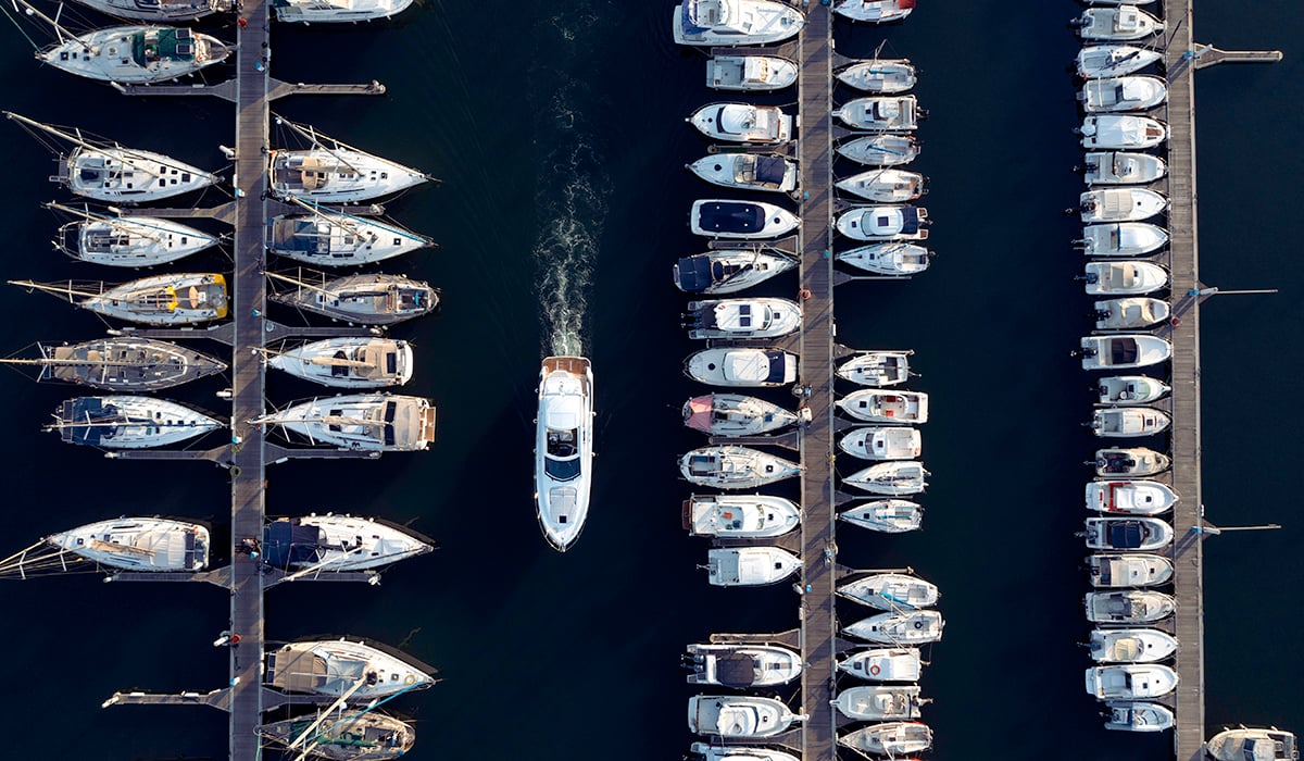 A boat pulling into a full marina.